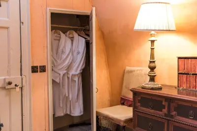 a room with a closet with a lamp and a chair at Queen Mary's Chamber in Peebles