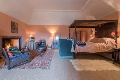 a bedroom with a canopy bed and a fireplace at Queen Mary's Chamber in Peebles