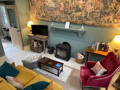 a living room with a couch and a fireplace at Barns Bothy in Peebles