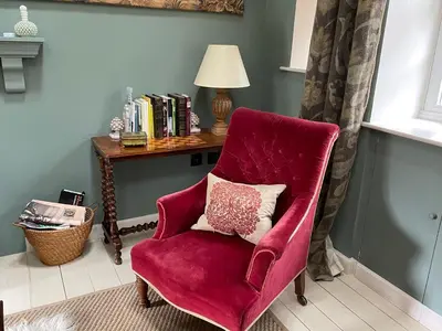 a red chair with a pillow in a room at Barns Bothy in Peebles