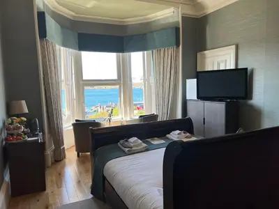a bedroom with a bed and a large window at Ardmor Guest House in Oban