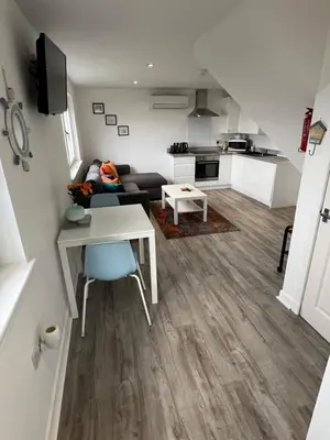 a living room with a couch and a table at The Wee Cottage by the Ferry in Gourock