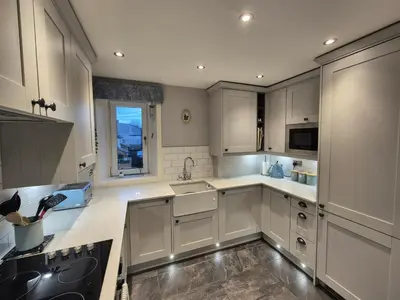a white kitchen with white cabinets and a window at Brae View Coastal Gem in Largs