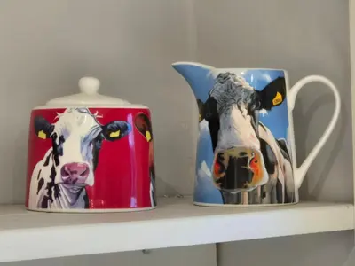 a shelf with two mugs with cows on them at Brae View Coastal Gem in Largs