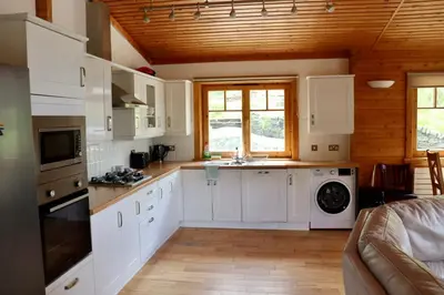 a kitchen with white cabinets and a stove top oven at Lodge 38 Rowardennan , Loch Lomond in Glasgow