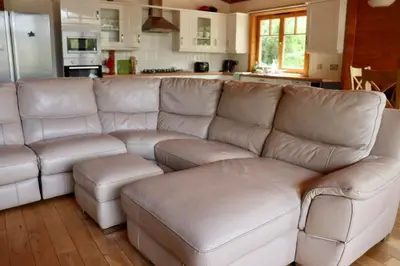 a living room with a white couch and a kitchen at Lodge 38 Rowardennan , Loch Lomond in Glasgow