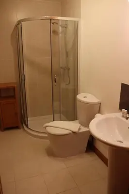 a bathroom with a shower and a toilet and a sink at Lodge 37 Rowardennan, Loch Lomond in Glasgow