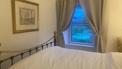 a bedroom with a bed and a window at Park side Cottage, Number 2, The Morays in Blackford