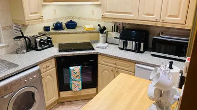 a kitchen with a stove top oven next to a microwave at Park side Cottage, Number 2, The Morays in Blackford