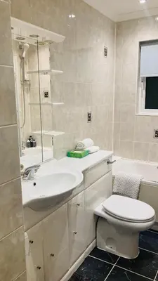 a white bathroom with a sink and a toilet at Park side Cottage, Number 2, The Morays in Blackford