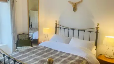 a bedroom with a bed and a mirror at Park side Cottage, Number 2, The Morays in Blackford
