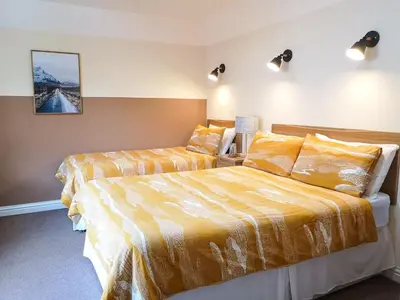 a bedroom with two beds with yellow sheets at Forest View Guesthouse, Kinlochleven WHW in Kinlochmore