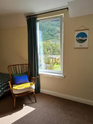 a bedroom with a chair and a window at Forest View Guesthouse, Kinlochleven WHW in Kinlochmore