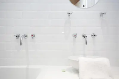 a white bathroom with a sink and faucet at Walkable 1BR Near Castle, Grassmarket, Food in Edinburgh