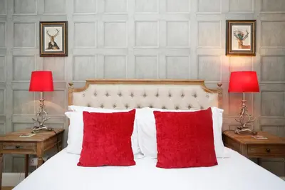 a bed with two red pillows and two lamps at Walkable 1BR Near Castle, Grassmarket, Food in Edinburgh