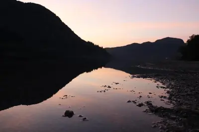 a body of water with a sunset in the background at Farmston Lodge in Callander