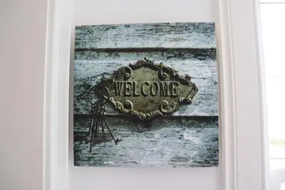a framed picture of a welcome sign on a door at Farmston Lodge in Callander