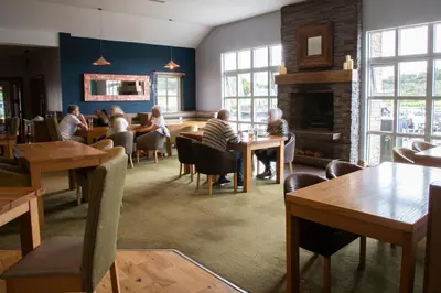 a group of people sitting at tables in a restaurant at The Boat House in Kilsyth
