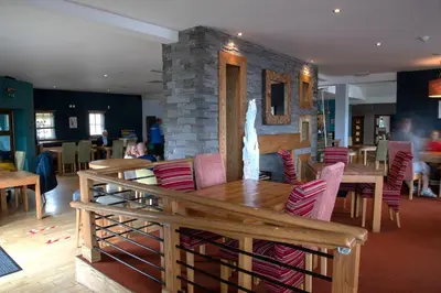 a dining room with a table and chairs and a fireplace at The Boat House in Kilsyth