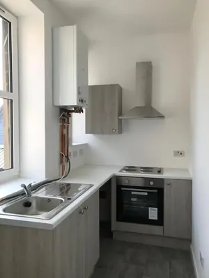 a white kitchen with a sink and a stove at Carvetii - Edward House A - 2 Dbl bed 1st floor flat in Dunfermline