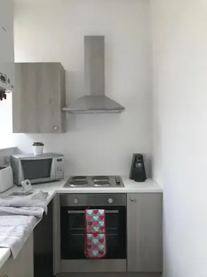 a kitchen with a stove and a microwave at Carvetii - Edward House A - 2 Dbl bed 1st floor flat in Dunfermline