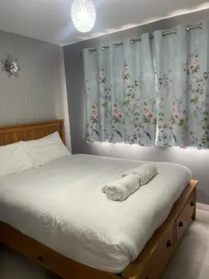 a bedroom with a bed with a cat sleeping on it at Chic 2 Bed Apartment with Free Parking- Recently Redecorated, 10 Minutes to City Centre in Edinburgh