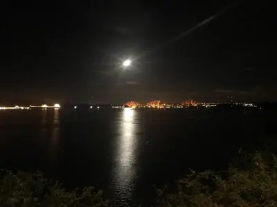 a full moon over a body of water at night at 1 Bed Studio - Sleeps 4 - Parking - Wifi in Saint Davids