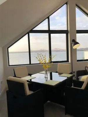 a dining room with a table and chairs and windows at 1 Bed Studio - Sleeps 4 - Parking - Wifi in Saint Davids