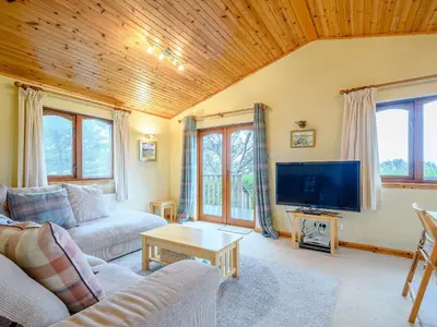 a living room with a couch and a tv at Ard Cuan in Torbeg