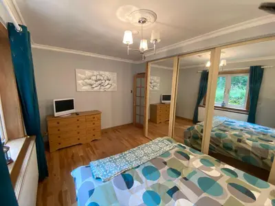 a bedroom with two beds and a mirror at Country Cottage Sleeps 6 w Hot Tub & Dog-Friendly in Moniaive