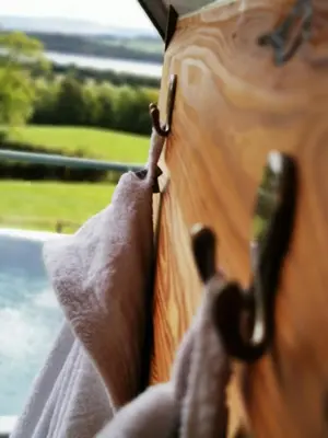 a person holding the handle of a wooden table at Bonnie Barns - Adults Only Luxury Lodges with hot tubs in Luss