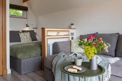 a living room with a couch and a table at Bonnie Barns - Adults Only Luxury Lodges with hot tubs in Luss