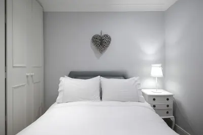 a bedroom with a white bed with a heart on the wall at Hamilton Place - Beautiful and central city apartment with private entrance sleeps 4 in Edinburgh