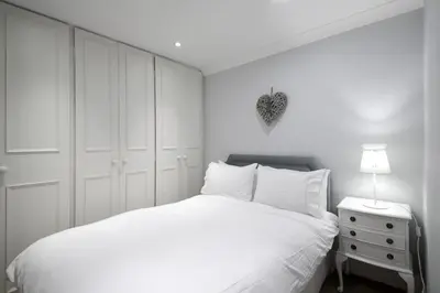 a white bedroom with a white bed and a nightstand at Hamilton Place - Beautiful and central city apartment with private entrance sleeps 4 in Edinburgh