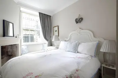 a white bedroom with a white bed and a window at Hamilton Place - Beautiful and central city apartment with private entrance sleeps 4 in Edinburgh