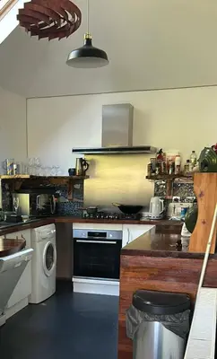 a kitchen with a stove and a washing machine at North Lodge Kilmun in Kilmun