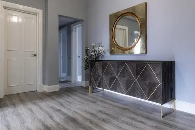 a room with a mirror on the wall and a dresser at Beautiful 4 bed flat in perfect central location in Glasgow