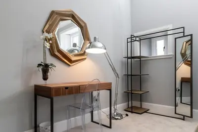 a desk with a lamp and a mirror on a wall at Beautiful 4 bed flat in perfect central location in Glasgow