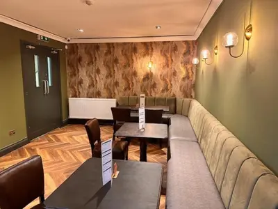 a living room with a couch and tables in it at Lomond Park Hotel in Balloch