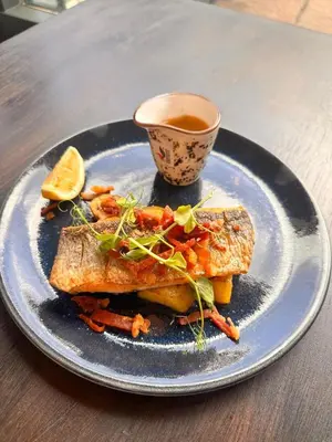 a plate of food with fish and a cup of tea at Lomond Park Hotel in Balloch