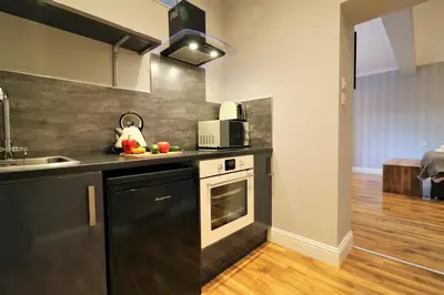 a kitchen with a sink and a stove top oven at Signature - Linden Cottage Room 1 in Airdrie
