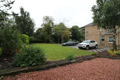 a yard with two cars parked in a parking lot at Signature - Linden Cottage Room 2 in Airdrie