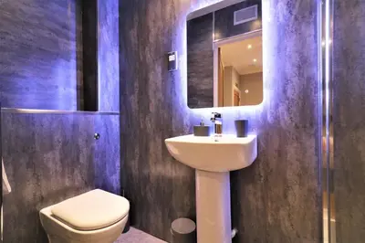 a bathroom with a sink and a toilet and a mirror at Signature - Linden Cottage Room 2 in Airdrie