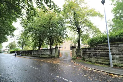 a person walking down a street in the rain at Signature - Linden Cottage Room 3 in Airdrie