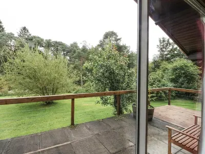 a balcony with a view of a yard at Millmore Cabin in Killin