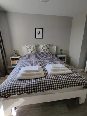 a bedroom with a bed with two towels on it at Anchors Away in Ayr