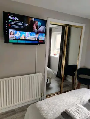 a bedroom with a flat screen tv on the wall at Anchors Away in Ayr