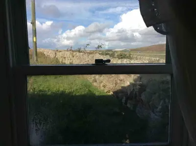 a window with a view of a field of grass at Upper Imeraval Cottage Sleeps 6 Pet-Friendly in Port Ellen