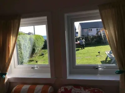 two windows in a room with a view of a yard at Upper Imeraval Cottage Sleeps 6 Pet-Friendly in Port Ellen