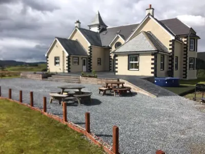 a building with picnic tables in front of it at Cumnock Knowes Holiday Retreat in Carsphairn